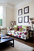 Artwork above co-ordinated lampshade and sofa fabric in living room of London townhouse, England, UK