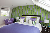 Green and purple wallpaper in attic bedroom of contemporary London townhouse, England, UK