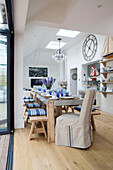 Long dining table in open plan living area with bi-fold doors looking out onto the garden in Dulwich home, London, UK