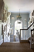 Seagrass carpeting with historic plasterwork in staircase of Sussex country home England UK