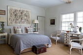 Blau-weiß gesteppte Bettdecke und Kunstwerke im Schlafzimmer eines historischen Landhauses in Sussex, England, Vereinigtes Königreich