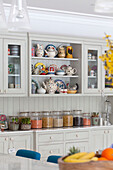 Storage jars and chinaware in kitchen of contemporary Surrey country home England UK
