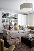 Blanket and cushions on sofa in living room of contemporary Surrey country home England UK
