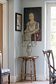 Historic artwork above side table with candlestick in Sussex home, England, UK