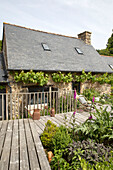 Wooden decking in garden exterior of modernised Brittany cottage, Western France