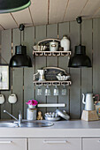 Black pendant lights above worktop in grey panneled kitchen of Brittany cottage Western France