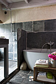 Shower cubicle with freestanding bath in slate bathroom of Brittany cottage, Western France
