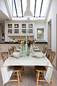 Wooden chairs at dining table under skylight in modernised Sussex Downs cottage, England, UK