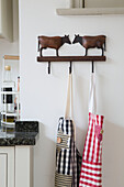 Two aprons hang on wooden cow hook in Sussex Downs kitchen, England, UK