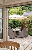 Parasol with garden chairs on patio of Sussex Downs home, England, UK
