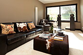 Ponyskin coverings on dark leather furniture in living room of contemporary new build, Kingston upon Thames, England, UK