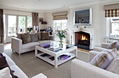 Square coffee table and sofa in front of fireplace in Kent home, England, UK