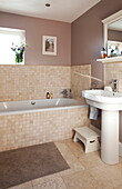 Gefliestes Badezimmer mit Fußbank und Sockelbecken in einem Bauernhaus in Staffordshire, England UK