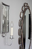 Mirrored wall sconce with decorative mirror in London townhouse England UK
