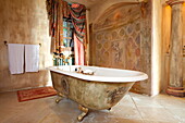 Freestanding bath with frescos and window fabric in French holiday villa