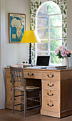 Wooden desk and chair at arched window of Herefordshire home with map of Africa, England, UK
