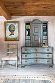 Antique side cabinet with upholstered chair in mountain chalet in Chateau-d'Oex, Vaud, Switzerland