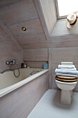 Folded towels at bathside with skylight window in mountain chalet, Chateau-d'Oex, Vaud, Switzerland