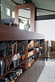 Shoe storage in dark wood shelving in contemporary SW London home, England, UK