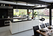 Stainless steel worktops in open plan kitchen dining room in contemporary SW London home, England, UK