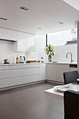Polished floor in white fitted kitchen of contemporary Brighton home, East Sussex, England, UK