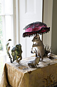Dormouse with parasol ornament on table at window in Burwash home East Sussex England UK