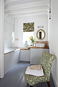 Leaf patterned chair on tongue and groove bathroom with glass shower screen in West Sussex home, England, UK