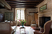 Schnittblumen auf Couchtisch mit Schlafcouch im Wohnzimmer mit Balken in einem französischen Bauernhaus an der Loire Frankreich Europa