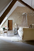 Dachgeschoss-Schlafzimmer mit Balken in einem französischen Bauernhaus an der Loire Frankreich Europa