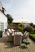 Wicker garden furniture with parasol on terrace of West Maling home, Kent, England, UK