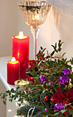 Beleuchtete Kerzen mit Vintage-Glas und Weihnachtsdekoration in einem Haus in West Sussex, England, UK