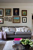 Framed artwork above grey sofa in living room of London home England UK