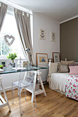 Daybed with trestle table in window of London bedroom, England, UK