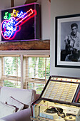 Neon guitar light with print of Elvis above juke box in UK farmhouse