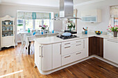 White fitted open plan kitchen in London family home, England, UK