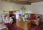 Wooden storage trunk with armchair and sofa in Ceredigion cottage living room Wales UK