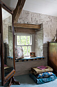 Vintage-Spiegel neben der Fensterbank in einem weiß getünchten Schlafzimmer in einem Cottage in Ceredigion, Wales UK
