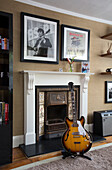 Electric guitar in front of fireplace with framed prints in Berkshire home, England, UK