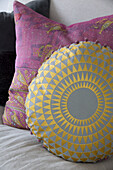 Gold and grey circular and pink cushions in London home England UK