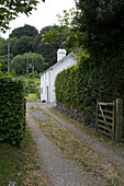 Blick durch das Tor zum weiß getünchten Cottage in Presteigne Wales UK