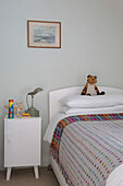 Soft toy on single bed with spotty blanket and side cabinet in Presteigne cottage Wales UK