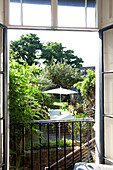 View through French windows to back garden of London townhouse, England, UK