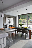 Open plan dining room and breakfast bar in contemporary Sussex home, England, UK