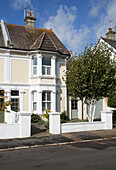 Yellow painted facade of semi-detached home in Shoreham by Sea   West Sussex   England   UK