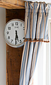 Striped curtains and clock face in Suffolk kitchen,  England,  UK