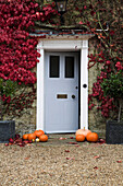 Pumpkins on gravel drive at doorway of London home in Autumn,  England,  UK