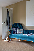Blue velvet chaise longue in room with coir matting in London home,  England,  UK