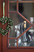 Heart shaped wreath on glass fronted cabinet in Berkshire home,  England,  UK
