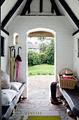 Blick durch die Türöffnung der weiß getünchten Veranda eines reetgedeckten Cottages in Sussex, England, Vereinigtes Königreich