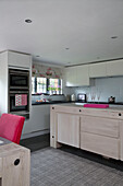 Pale wood kitchen island with integral oven in Sussex cottage   England   UK